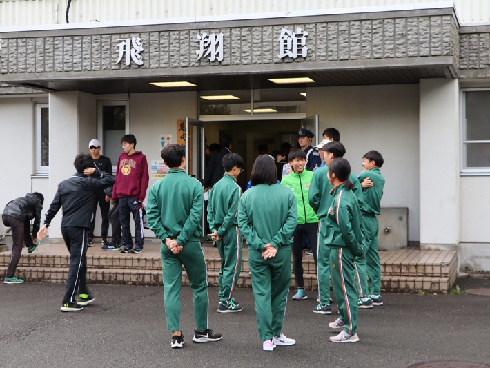 体育館の前で、選手と話す部員たち