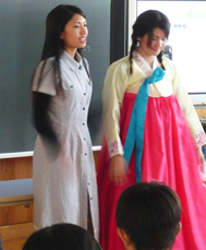チマチョゴリを着る蕪木真梨弥さん(2年)と韓服の説明をする中村久麻里さん(3年)