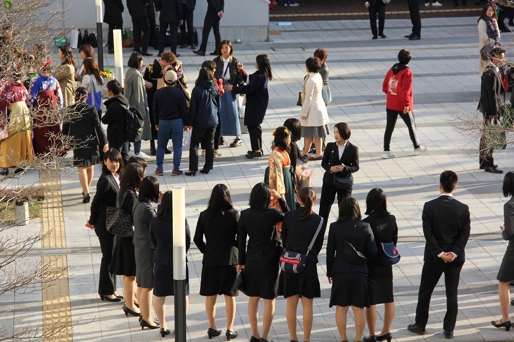 先輩を見送る後輩学生のスーツ姿も晴れやかに見えます。