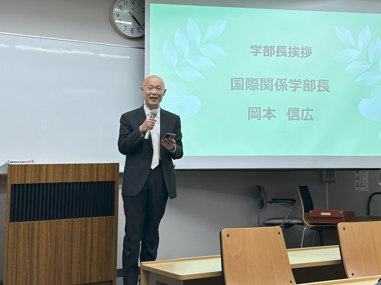 卒業生へ向け挨拶をする岡本信広学部長