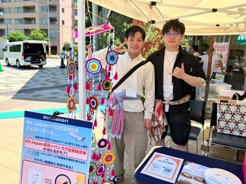 後援企業株式会社エアージャパンのブースでお手伝いをする学生たち。