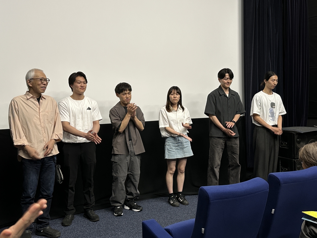 上映後のティーチインで挨拶する神部先生とゼミ生。