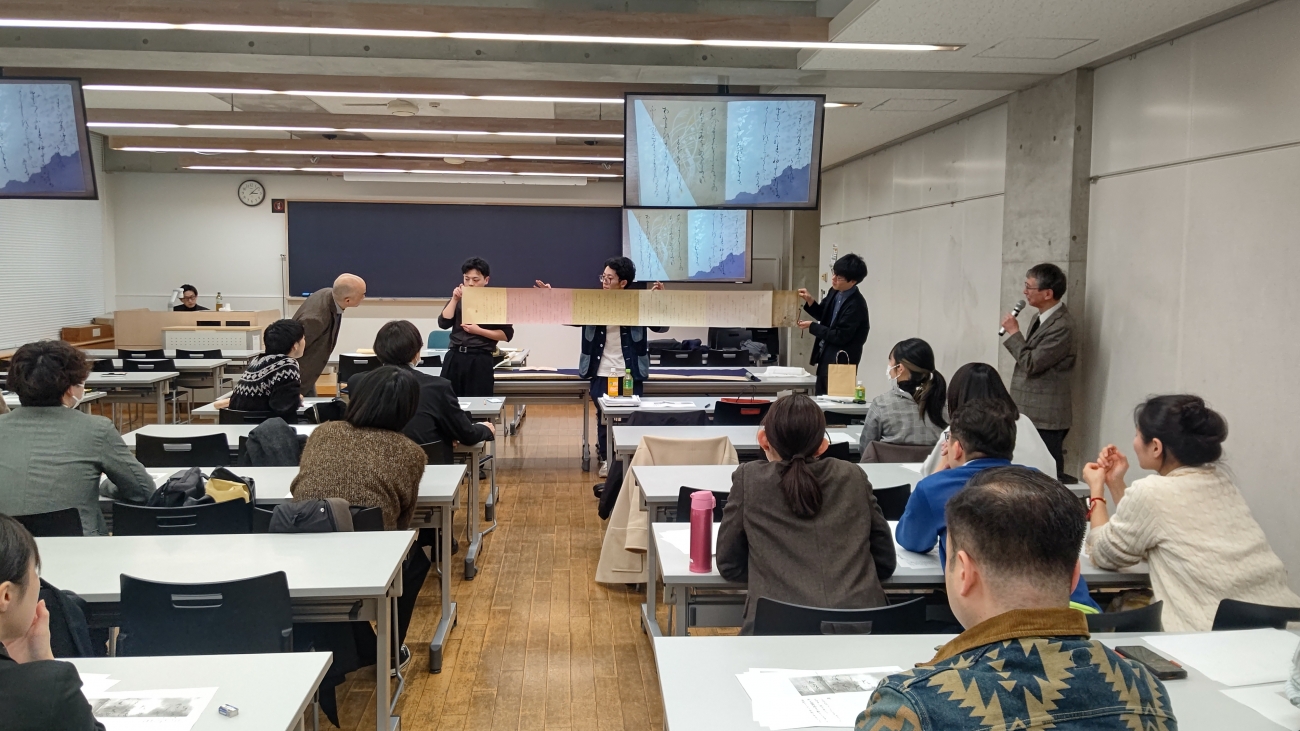倉橋先生の師である池内艸舟先生が臨書された高野切第一種巻第二十を鑑賞している様子